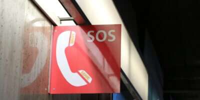 a red sign hanging from the side of a building